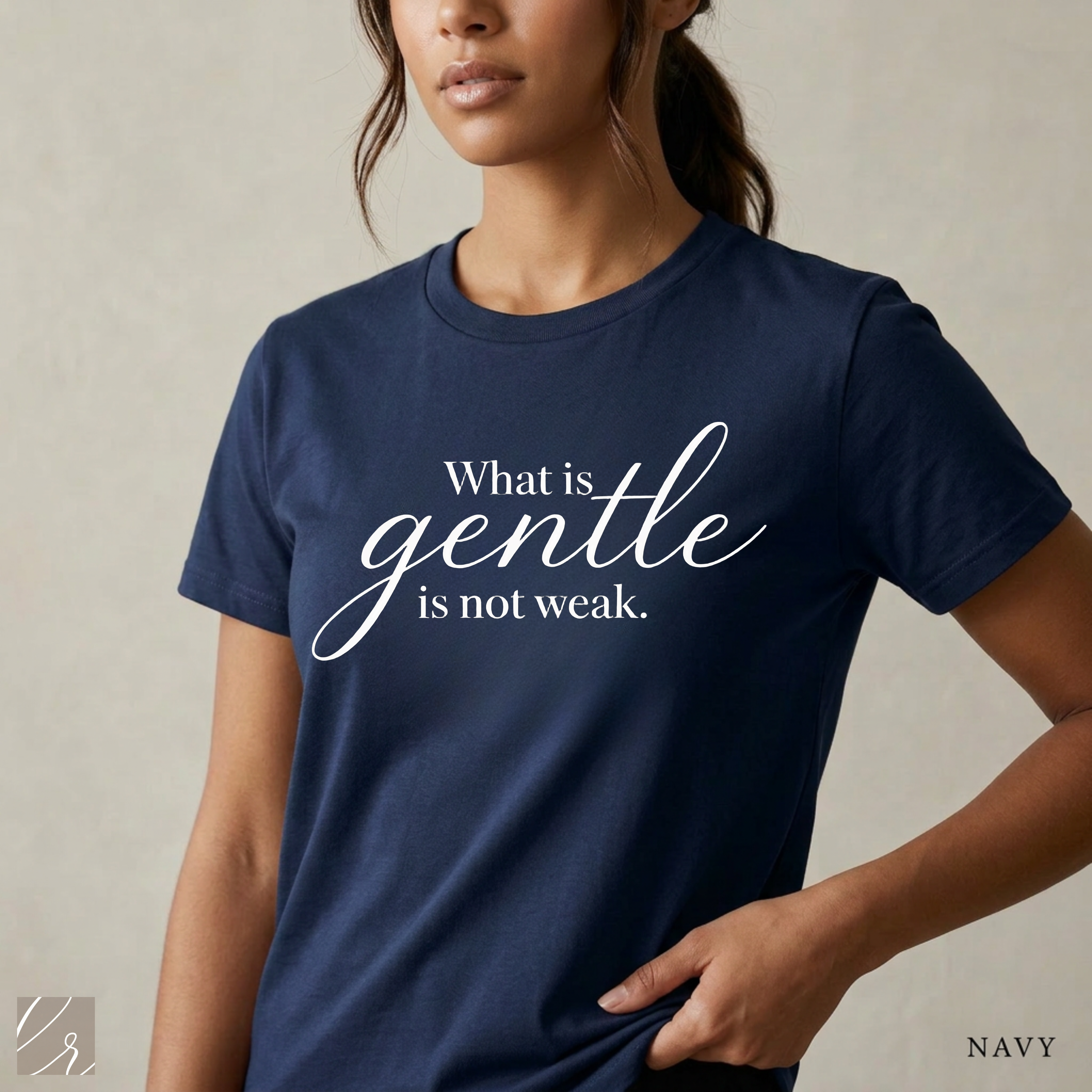 Close-up product photo of a women’s navy graphic tee with elegant white typography, shown on a model in soft natural light with a clean neutral background and refined modern styling.
