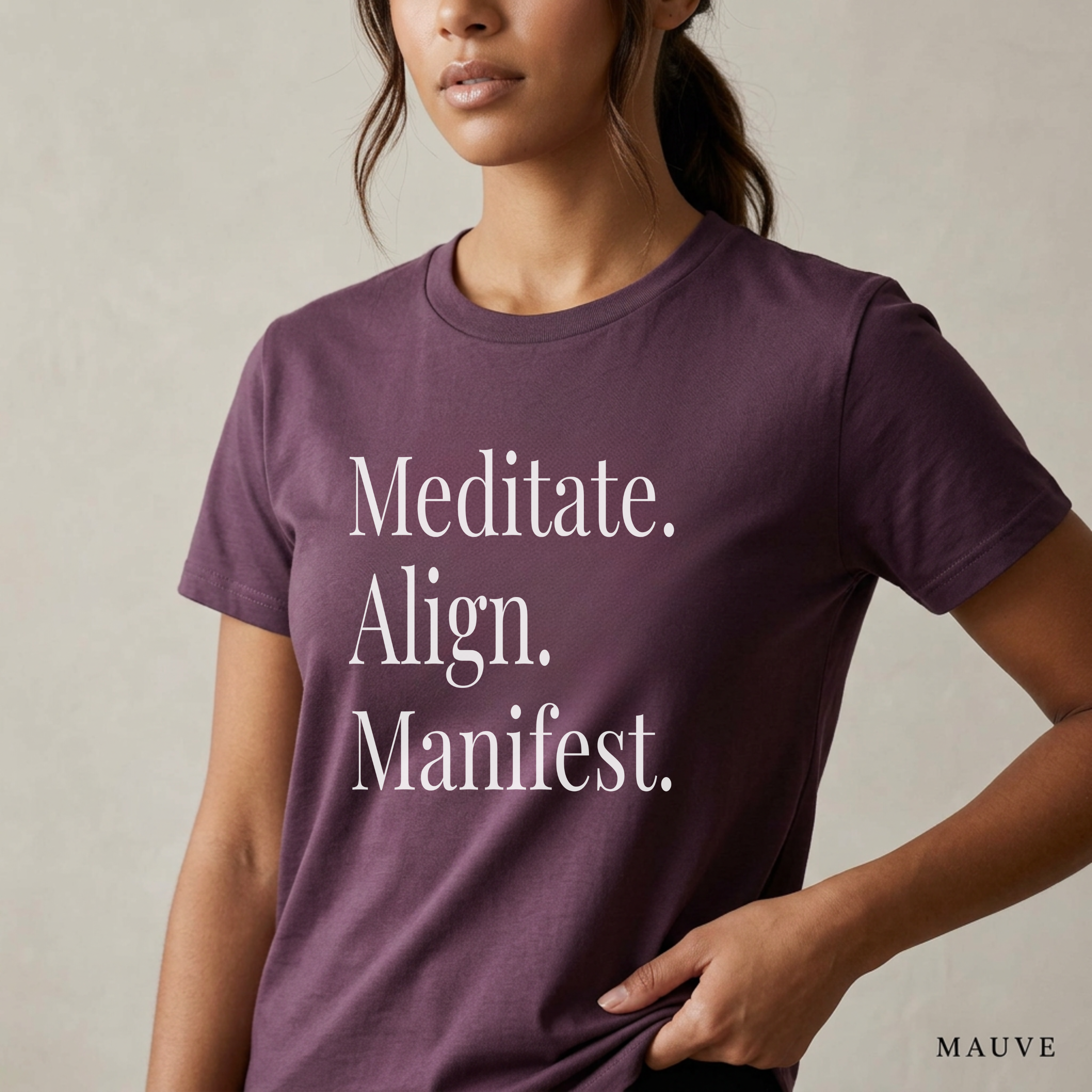 Close-up product photo of a women’s mauve purple graphic tee with elegant white typography, shown on a model in soft natural light with a clean neutral background and refined modern styling.