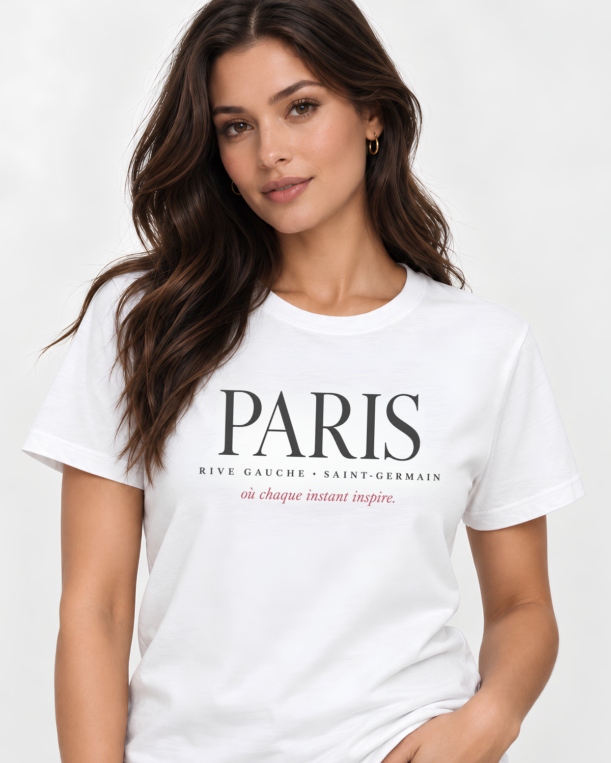 A woman wearing a white short-sleeve crewneck T-shirt with 'PARIS' printed in black across the chest, along with smaller black and pink text below, against a clean white background.