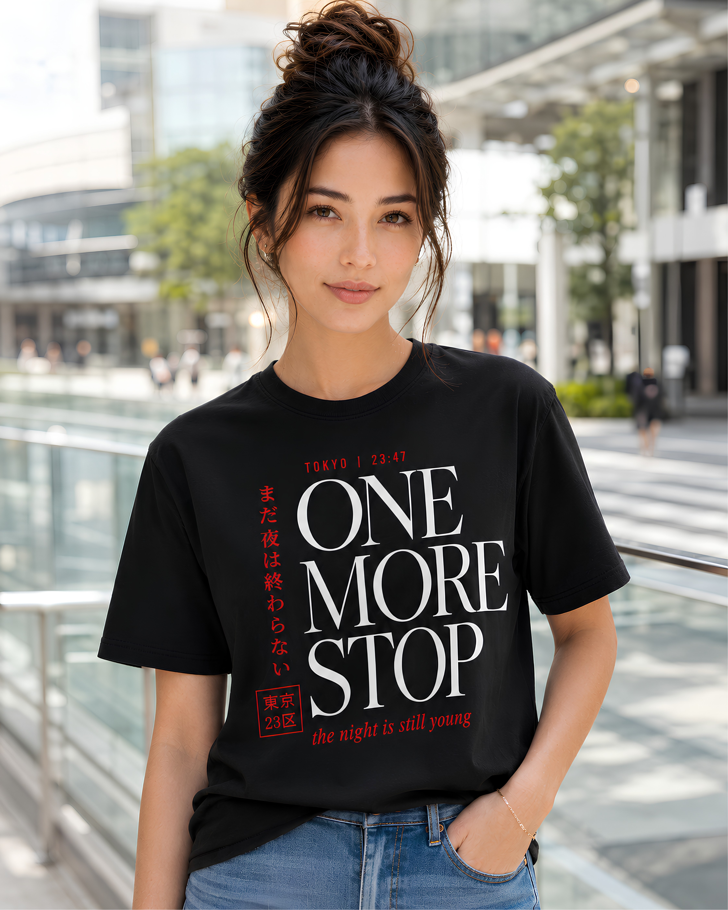 Woman wearing black Tokyo Japan One More Stop travel T-shirt near a modern Tokyo train station