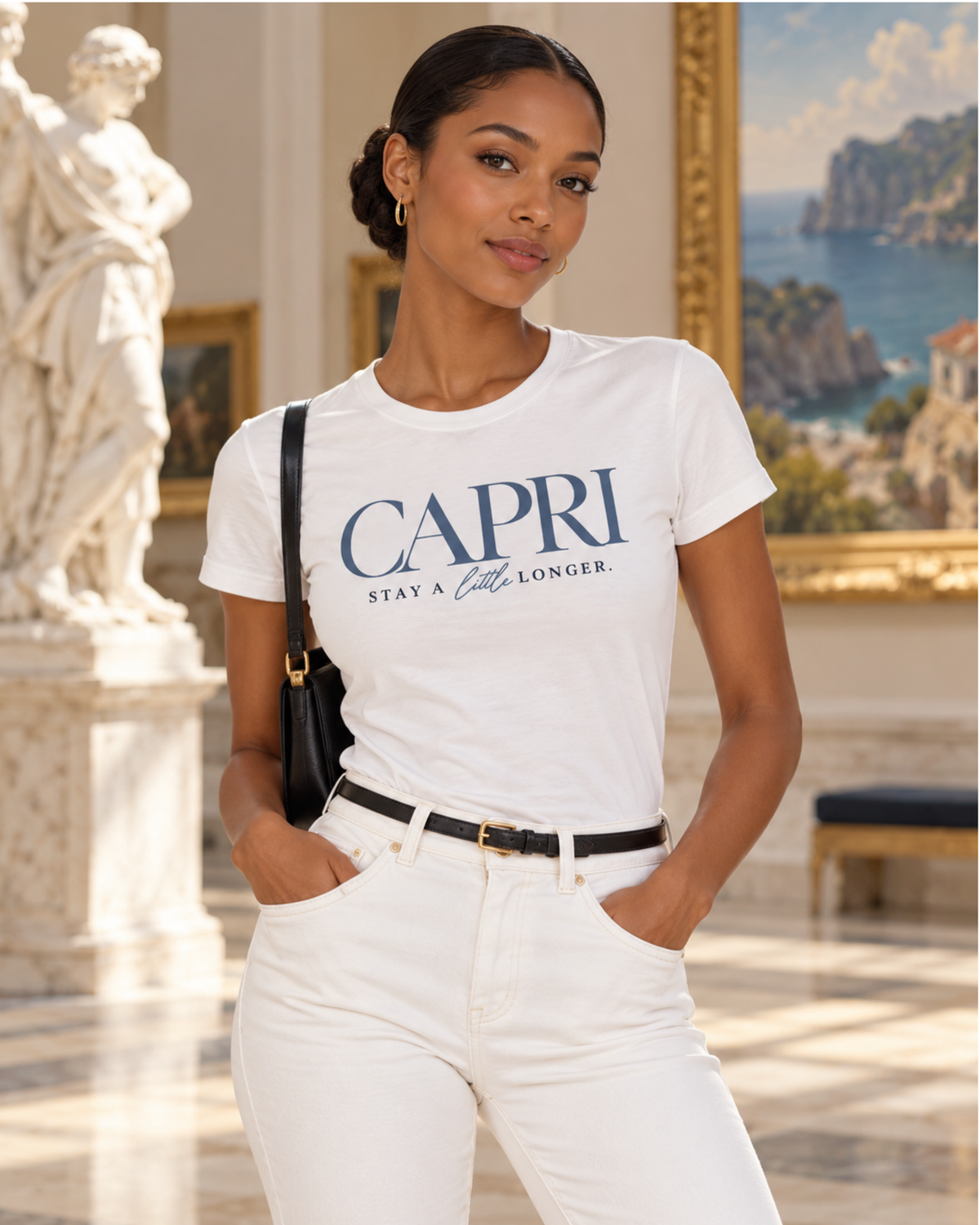 Woman wearing white Capri travel tee with white trousers and black belt in an elegant art gallery