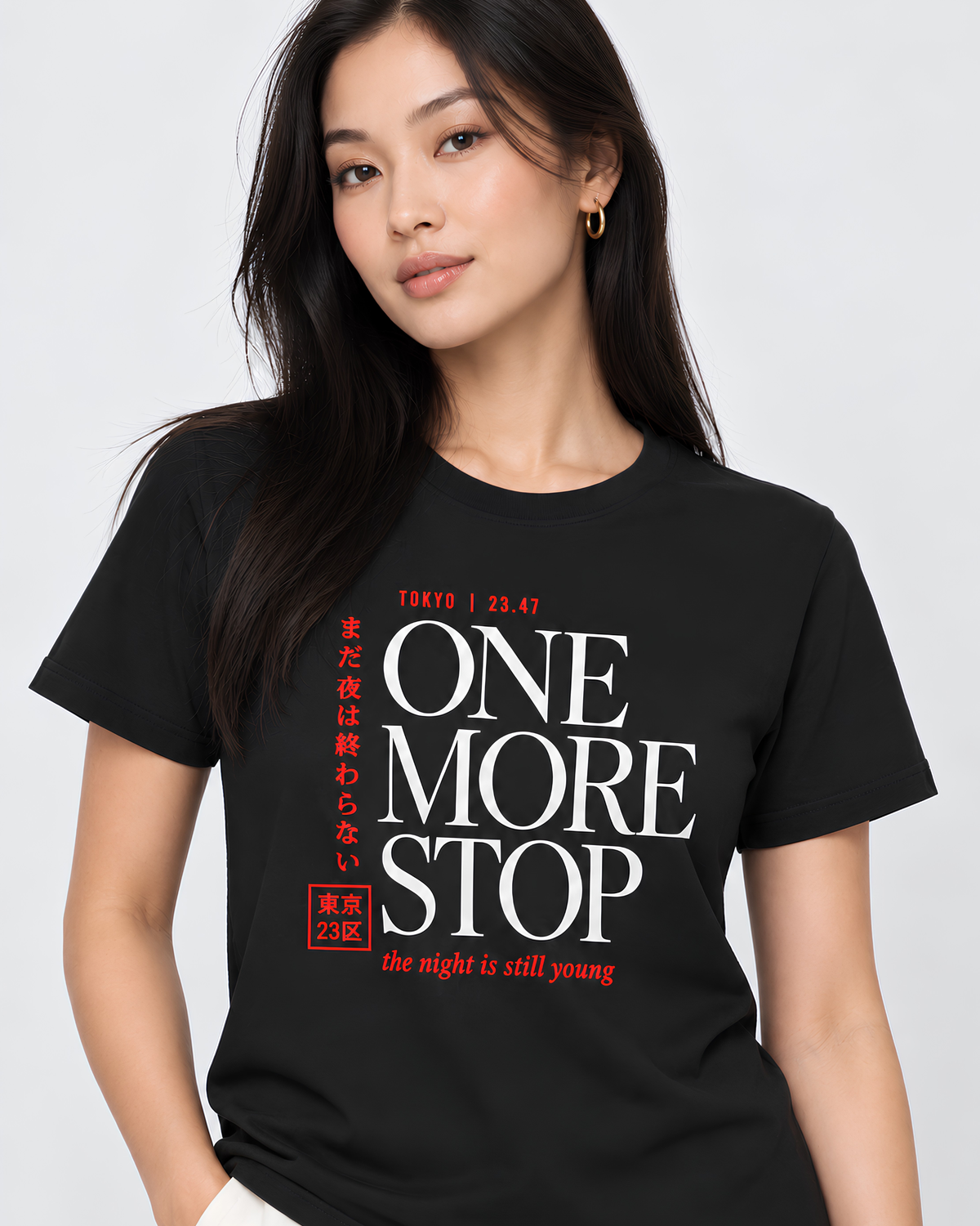 A woman wearing a black short-sleeve graphic T-shirt with bold white and red text reading 'ONE MORE STOP' and smaller Japanese text, photographed against a light gray studio background.