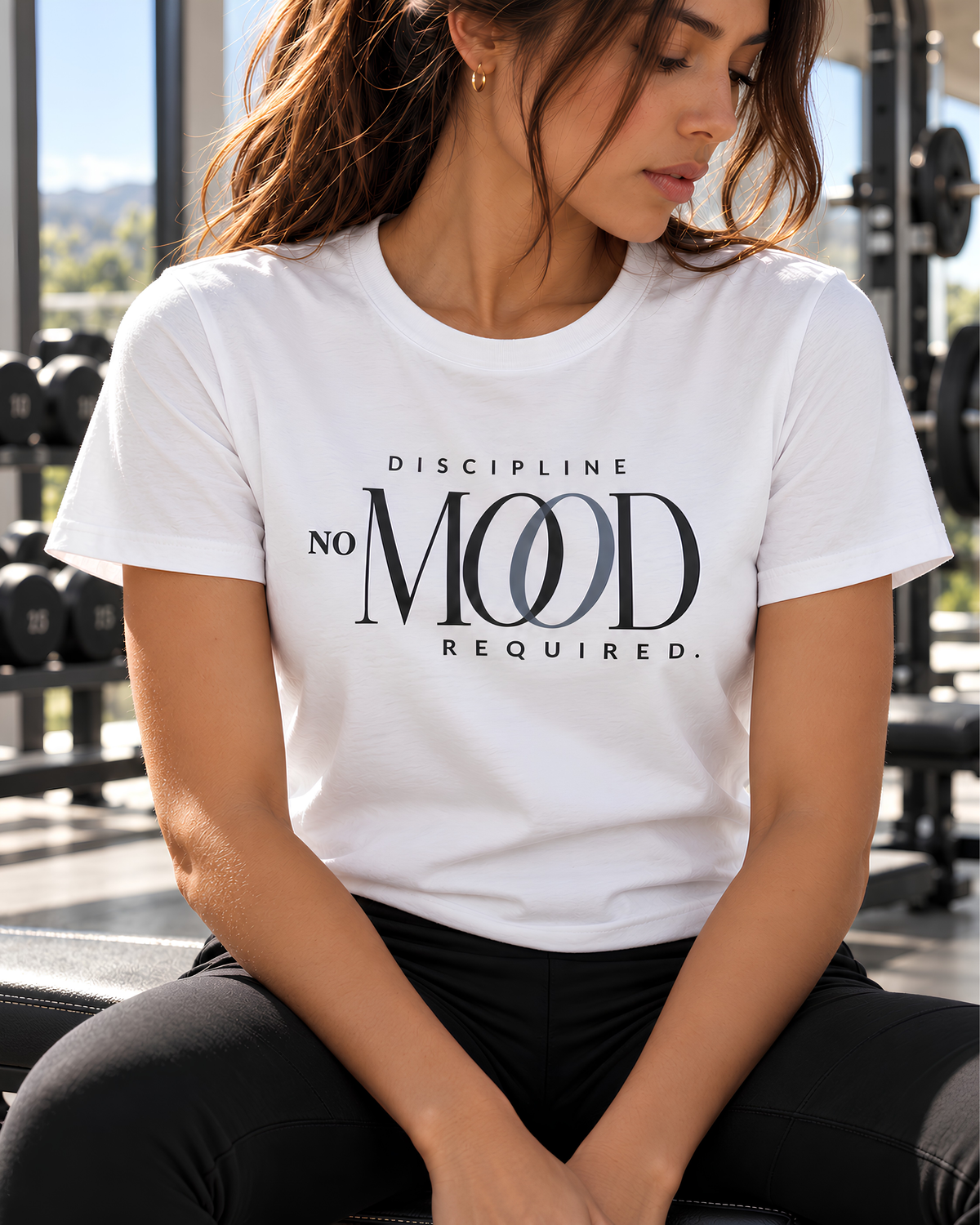 Woman wearing a white ‘Discipline No Mood Required’ graphic tee, a premium women’s motivational workout shirt for gym, Pilates, fitness and everyday wear.