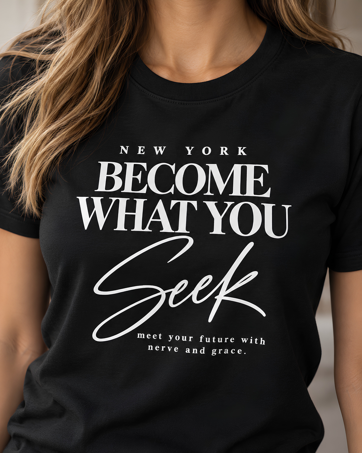 Black New York graphic tee for women featuring ivory “Become What You Seek” lettering on the front.