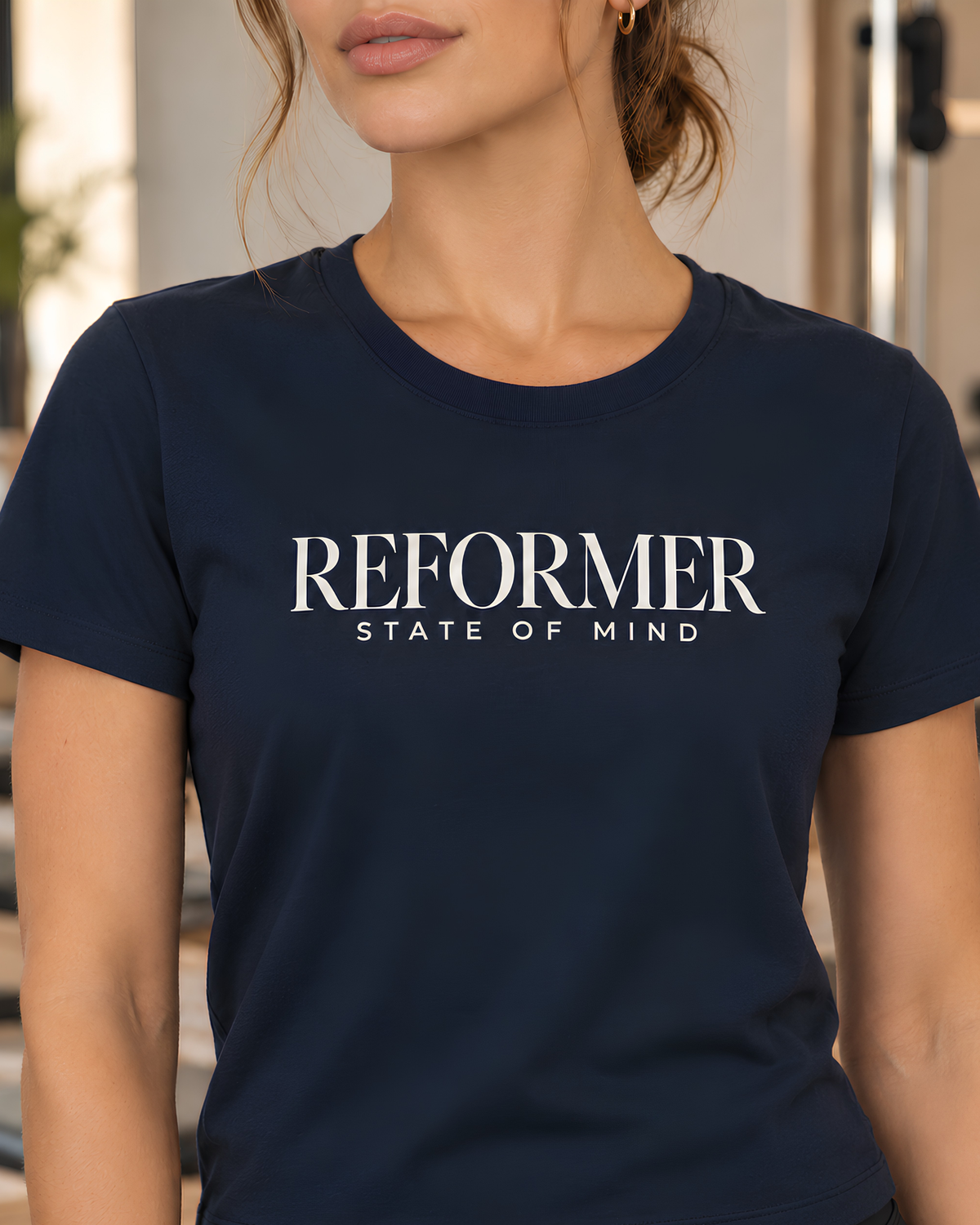 Navy women’s T-shirt with ivory “REFORMER STATE OF MIND” typography.